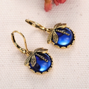 Makroaufnahme der Libellen-Ohrringe mit blauem Stein und antikem Gold-Finish