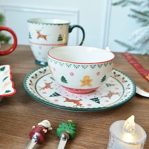 Christmas ceramic tableware set featuring reindeer and gingerbread man on a wooden table