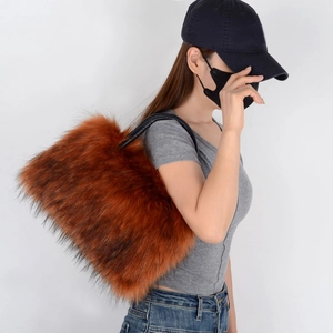 Brown long plush tote bag detail with black leather strap carried by a side-view model