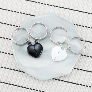 Magnetic black and white heart-shaped metal keychains for couples in a matching set