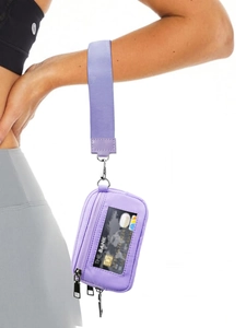 Detalle del bolso de muñeca deportivo púrpura con tela impermeable y ventana de ID