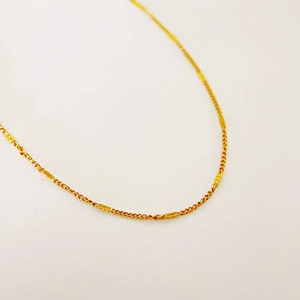 Detailed close-up of 18k gold plated stainless steel glitter chain necklace texture