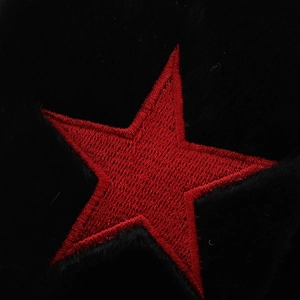Gros plan d'une étoile rouge brodée sur la peluche noire épaisse d'une tuque d'hiver