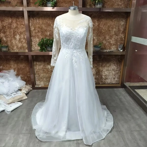 Detailed view of the V-neck lace bodice and multi-layered tulle skirt on a white wedding gown