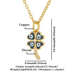 Close-up of golden four-leaf clover pendant necklace with cubic zircon evil eye details