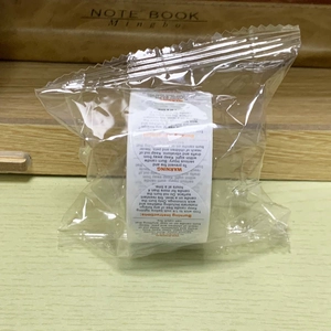 Detail of candle safety warning labels roll showing burning instructions in clear bag