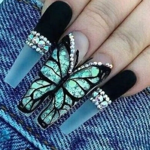 Detailed view of long coffin press-on nails with green butterfly motif and rhinestones