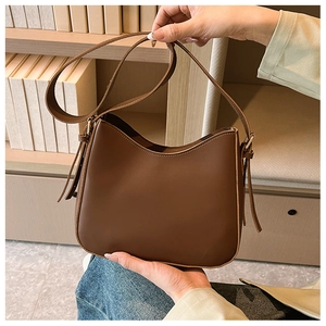 Détail du sac bandoulière croissant en cuir PU marron café avec ornement de gland