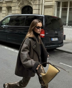 Street style view of a brown faux shearling jacket with oversized collar and casual fit