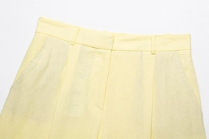 Details der hellgelben Leinen-Shorts mit Gürtelschlaufen und Seitentaschen-Struktur