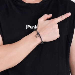 Close-up of black punk chain bracelet with a classic anchor pendant worn on a male wrist