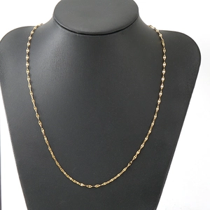 Detailed view of an 18K gold-plated lip chain necklace on a black mannequin bust