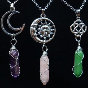 Detailed view of wire-wrapped natural crystal pendants with moon and celtic knot designs