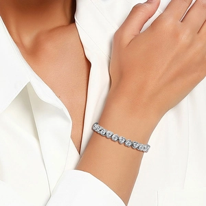 Elegant silver heart-shaped bracelet with AAA zircon stones worn on a female wrist