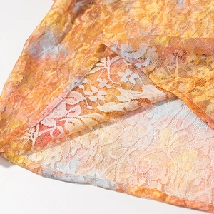 Macro detail of sweet lace mesh hem with orange floral print and double-stitch seam