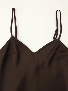 Detail of V-neckline and thin adjustable straps on a dark brown satin camisole top