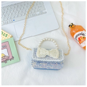Détail du mini sac à paillettes bleu clair avec poignée en perles et chaîne dorée
