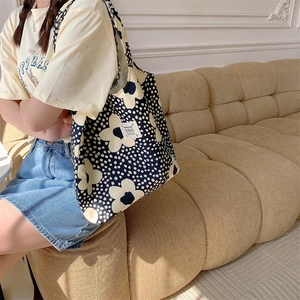 Dettaglio della borsa tote in tela floreale con etichetta LOVE in un contesto lifestyle