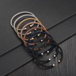 Close-up of flexible mesh cable bracelets in multiple metallic colors with polished end caps