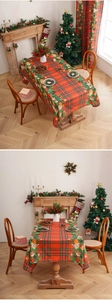 Detailed pattern of red Christmas tablecloth with gingerbread house and pine branches