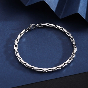 Detailed view of silver stainless steel Cuban link bracelet with lobster clasp on origami