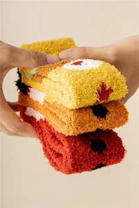 Close-up of soft coral fleece Christmas socks in warm yellow orange and red colors
