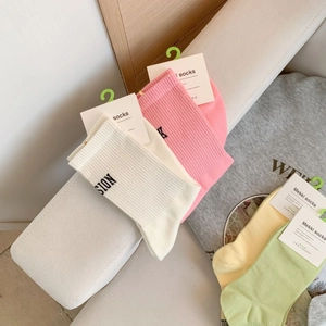 Detail of ribbed cotton mid-calf socks in white, pink, yellow and green colors