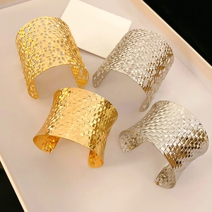 Detailed view of wide open bracelets featuring woven and cut-out mesh patterns
