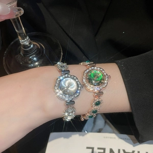 Detail of luxury rhinestone floral bezel watches with emerald and silver dials