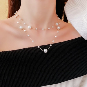 Detail of a vintage double-layer gold necklace with pearls on a female neck and collarbone