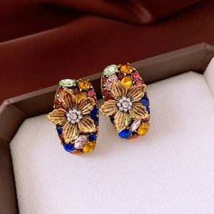 Detailed macro view of vintage flower earrings with colorful rhinestones and pearls
