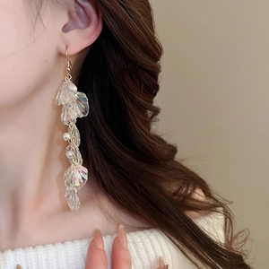 Close-up of elegant iridescent shell tassel earrings on model with long metal chains