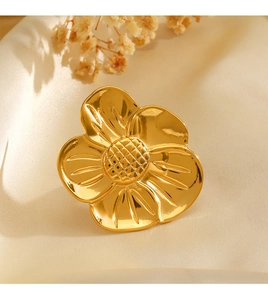 Macro shot of 18K gold plated flower ring showing detailed petal texture on white silk