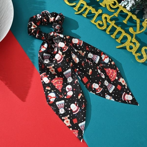 Detail of Christmas themed black satin hair scrunchie with festive ribbon streamers