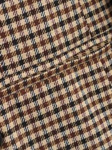 Nahaufnahme von braunem und beige kariertem Wollstoff mit detaillierter Webstruktur