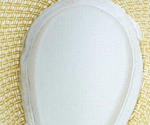 Macro detail of the woven straw texture and clean stitching on the white inner lining