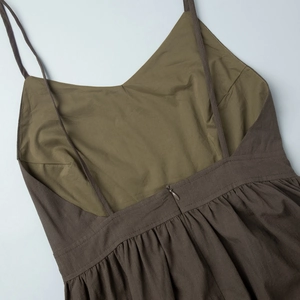 Détail d'une robe marron en coton montrant les plis fins et la fermeture éclair invisible