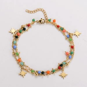 Detail of bohemian gold layered bracelet with multi-color beads and gold star charms