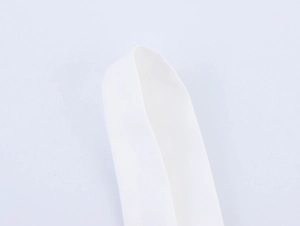 Detail of white canvas strap texture and shell chain link on beach vacation dress
