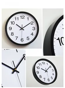 Detail of modern black quartz wall clock featuring matte frame and white Arabic dial