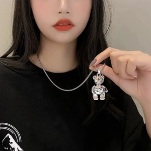 Detail of a silver mechanical bear necklace pendant on a trendy layered chain
