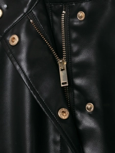 Detail von hochglänzenden Goldreißverschlüssen und Druckknöpfen auf schwarzer Kunstlederjacke