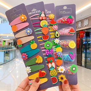 Close-up of colorful fruit hair clip set with strawberry and daisy designs for girls