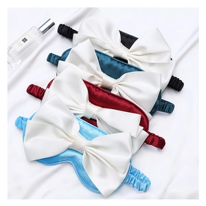 Detail of silk sleep masks with large white bows in black, green, burgundy, and blue colors
