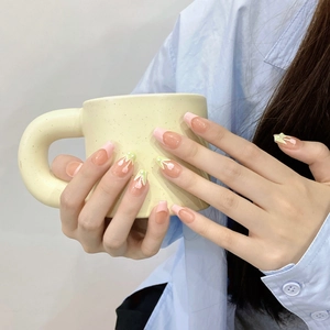 Pink tulip press-on nails with French tips and pearl details on a long ballerina shape