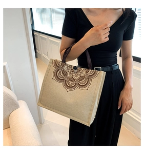 Detail view of large linen tote bag with brown mandala pattern and purple handles