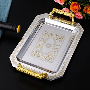 Detailed close-up of a rectangular silver mirror tray with ornate gold floral patterns