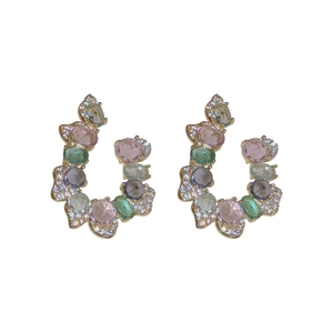 Exaggerated C-shaped gold earrings with colorful gemstones and pavé zircon accents