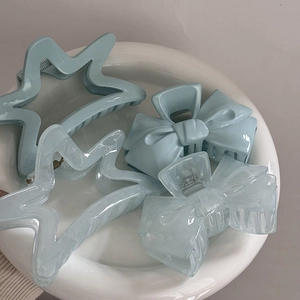 Blue star and bow hair claws on a ceramic plate, elegant shark hair clips for women
