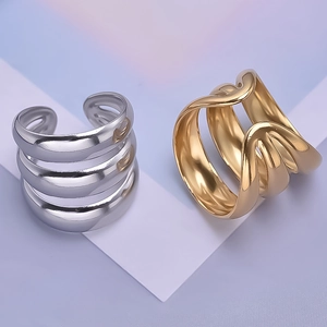 Macro shot of tiered wavy stainless steel rings in polished gold and silver finishes